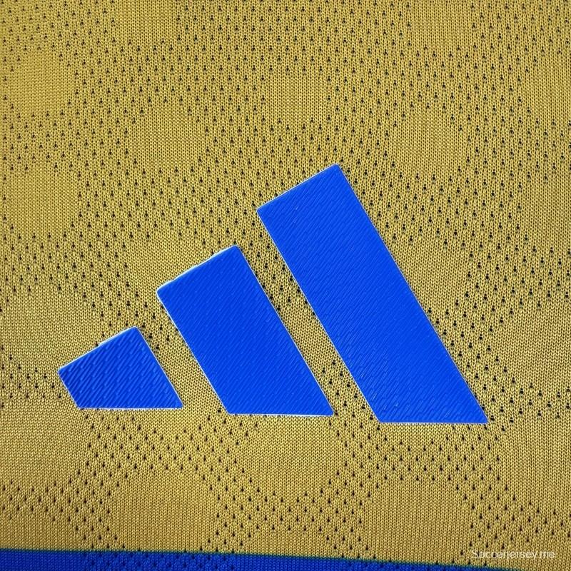 قميص اللاعب نسخة 25/26 لفريق تيغريس UANL باللون الذهبي مع شريط أزرق على الصدر، وشعار الذكرى الخامسة والستين، وقميص Sportiumbet