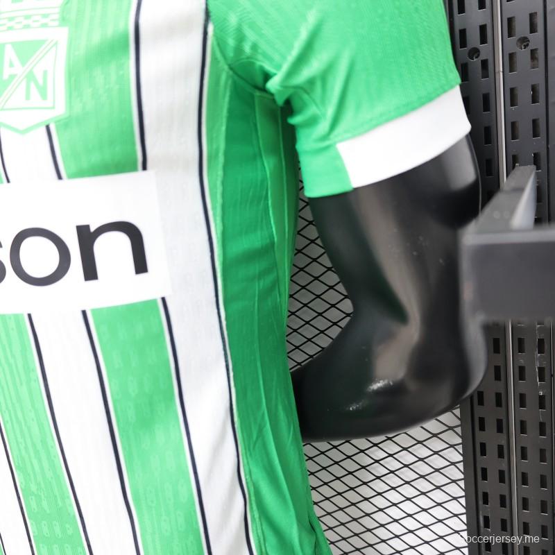 قميص اللاعب رقم 26/27 لفريق أتلتيكو ناسيونال باللونين الأخضر والأبيض مع خطوط عمودية (قميص المباريات على أرض الفريق)