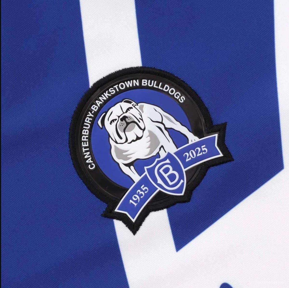 25/26 قميص كانتربري-بانكستاون بولدوغز أبيض مع أكتاف زرقاء خارج الملعب